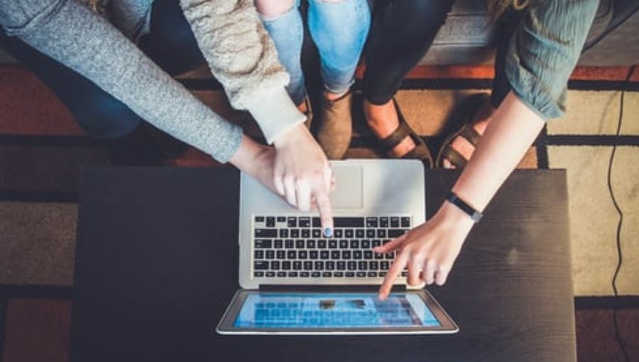 4 ways to simplify marketing compliance review - people pointing at laptop's screen from above