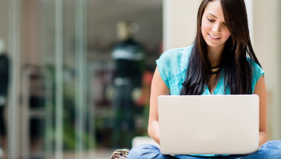 Woman in casual clothes working on laptop to make her website ADA compliant